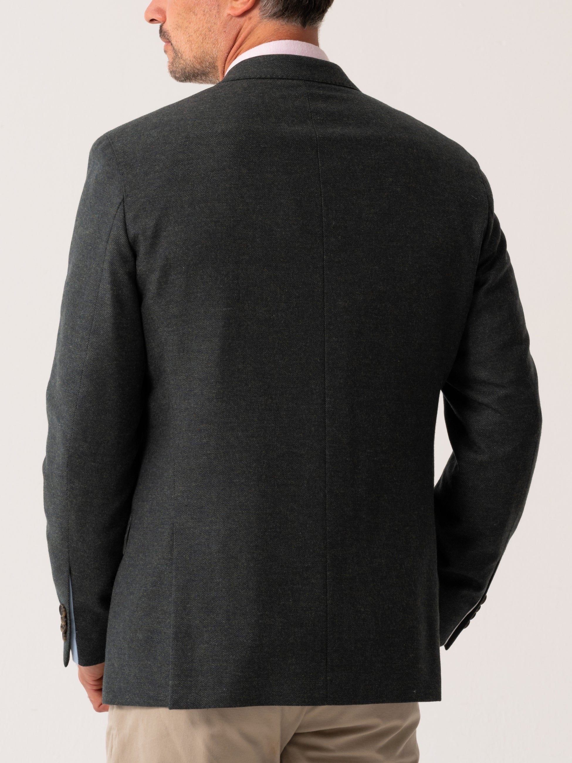 Back view of Olive blazer worn by a man on a light grey background