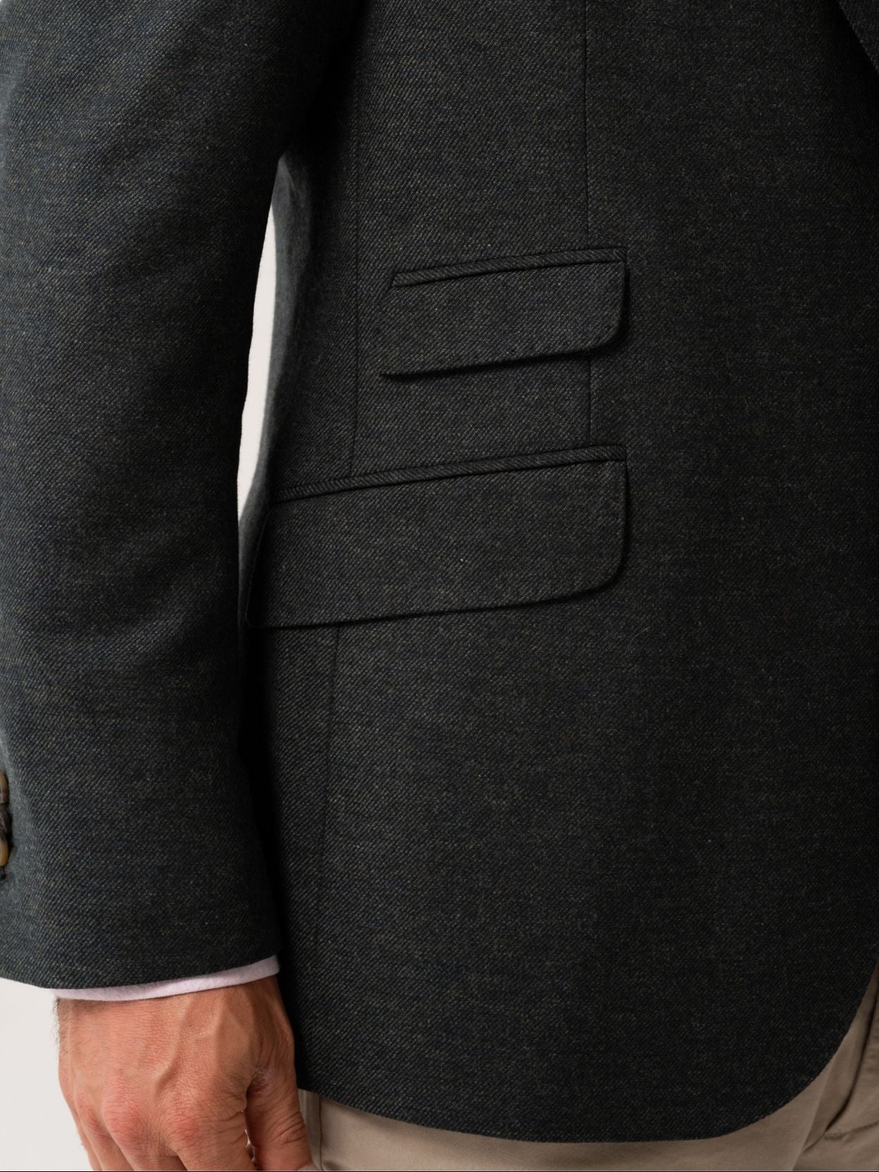 Close-up of a olive blazer with ticket pockets on a white background