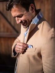 Men’s camel wool overcoat with colourful detailing under the collar.