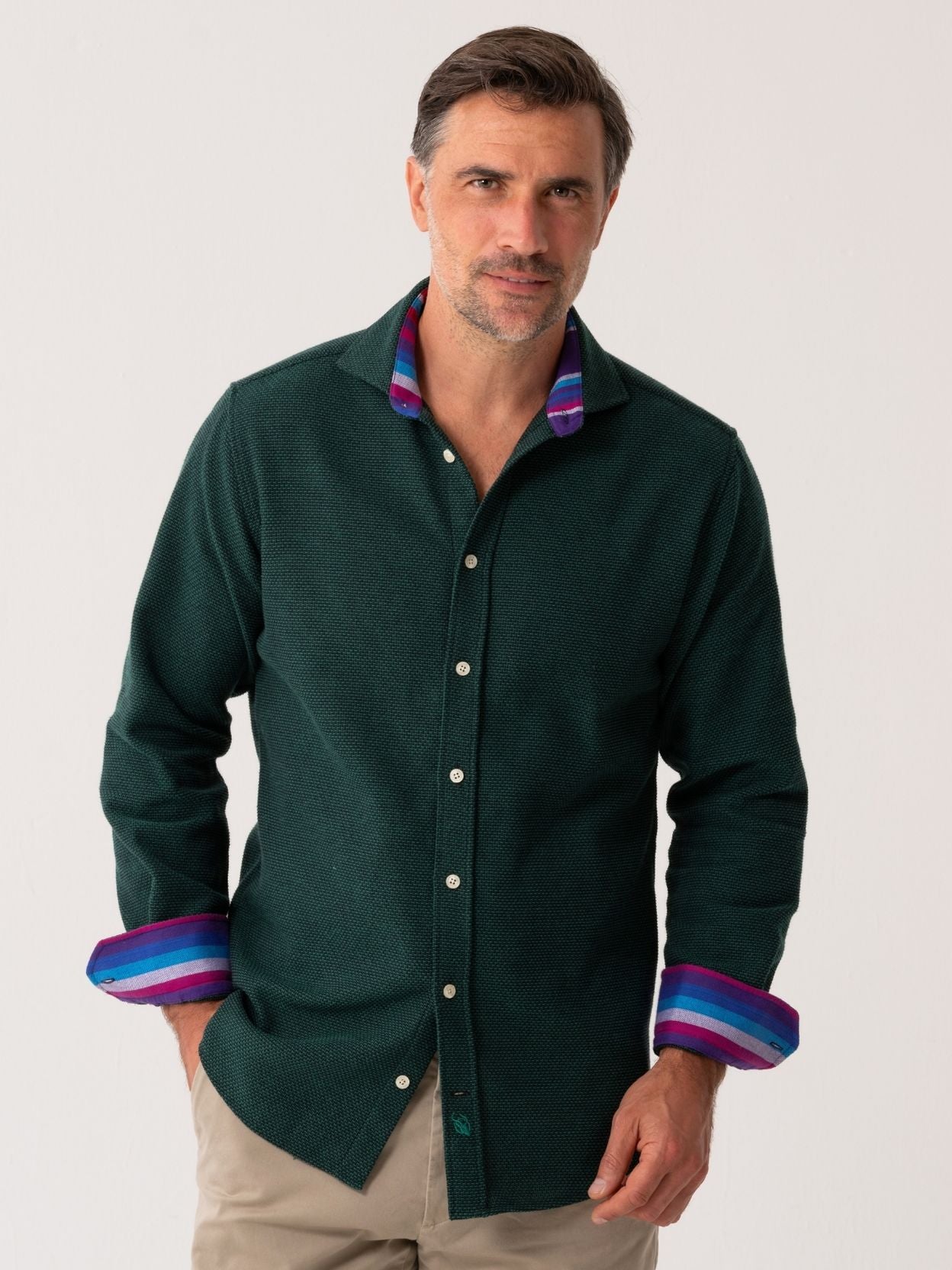 Man wearing a Green Basketweave Knit dark green shirt with colourful cuffs and collar against a white background