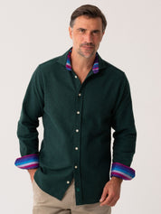 Man wearing a Green Basketweave Knit dark green shirt with colourful cuffs and collar against a white background