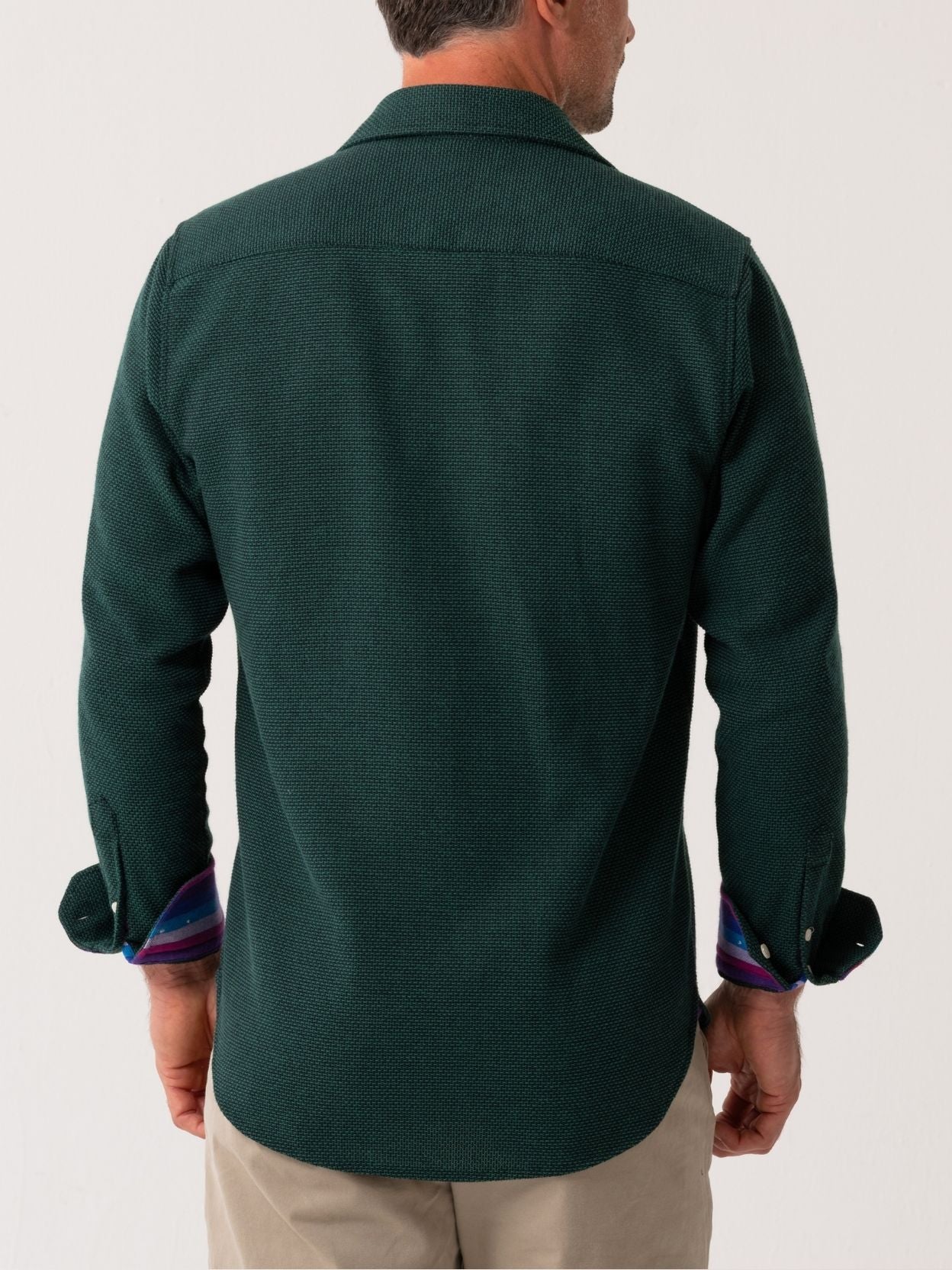 Back view of a green shirt worn by a person on a white background