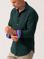Man wearing a green shirt with a colorful collar against a white background