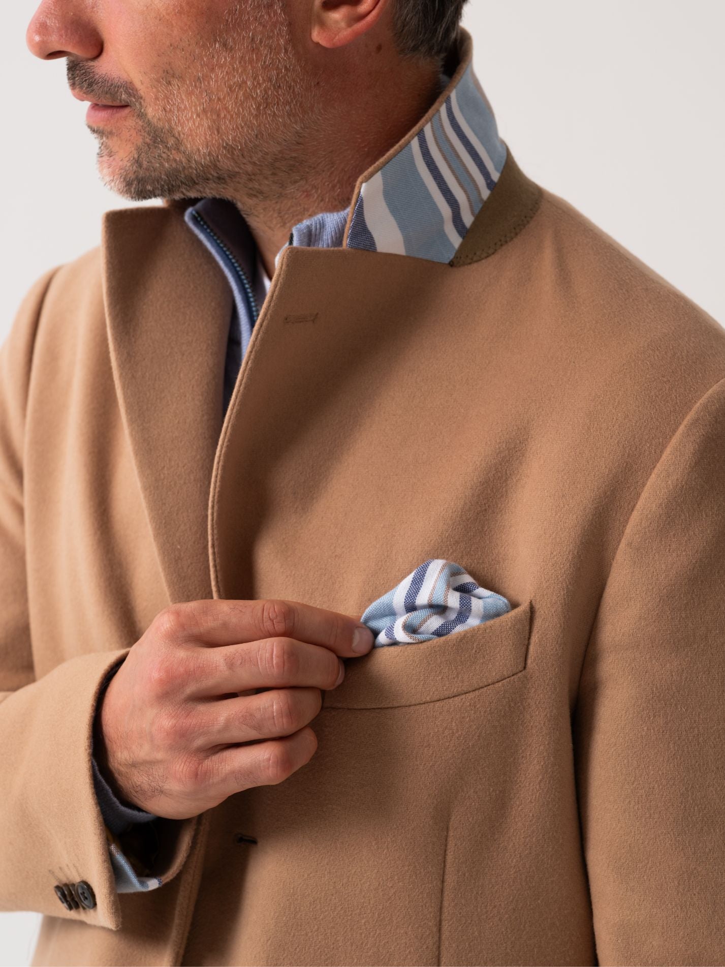 Close-up of notch lapel on camel wool overcoat