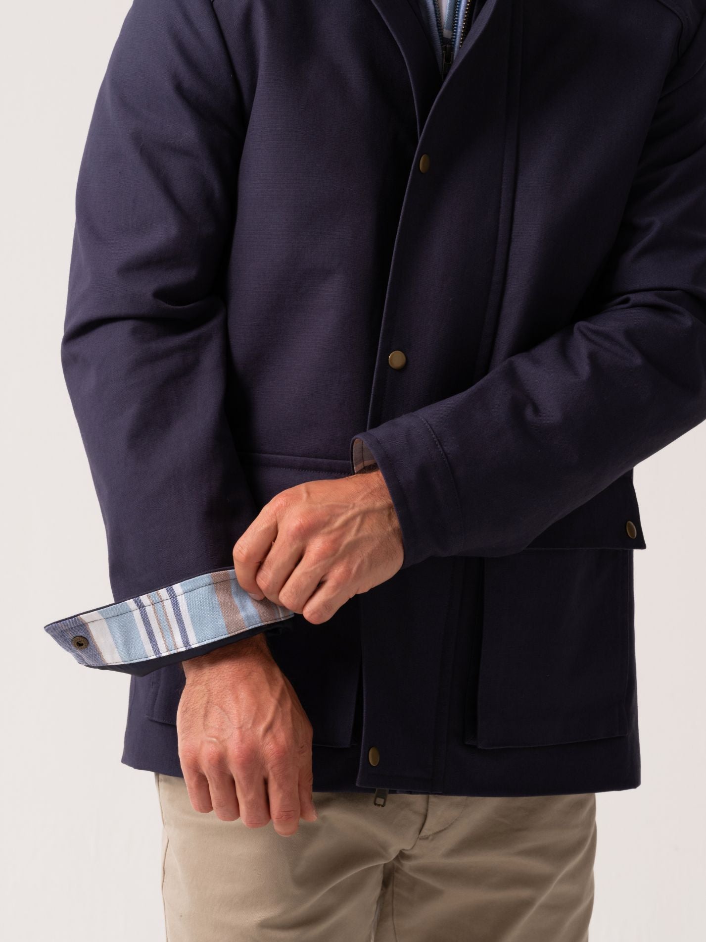 Mens navy outerwear coat with water resistant finish - cuff detail view on plain background 