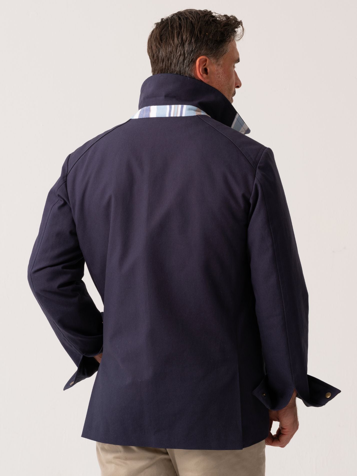 Mens navy outerwear coat with water resistant finish - back view on plain background 