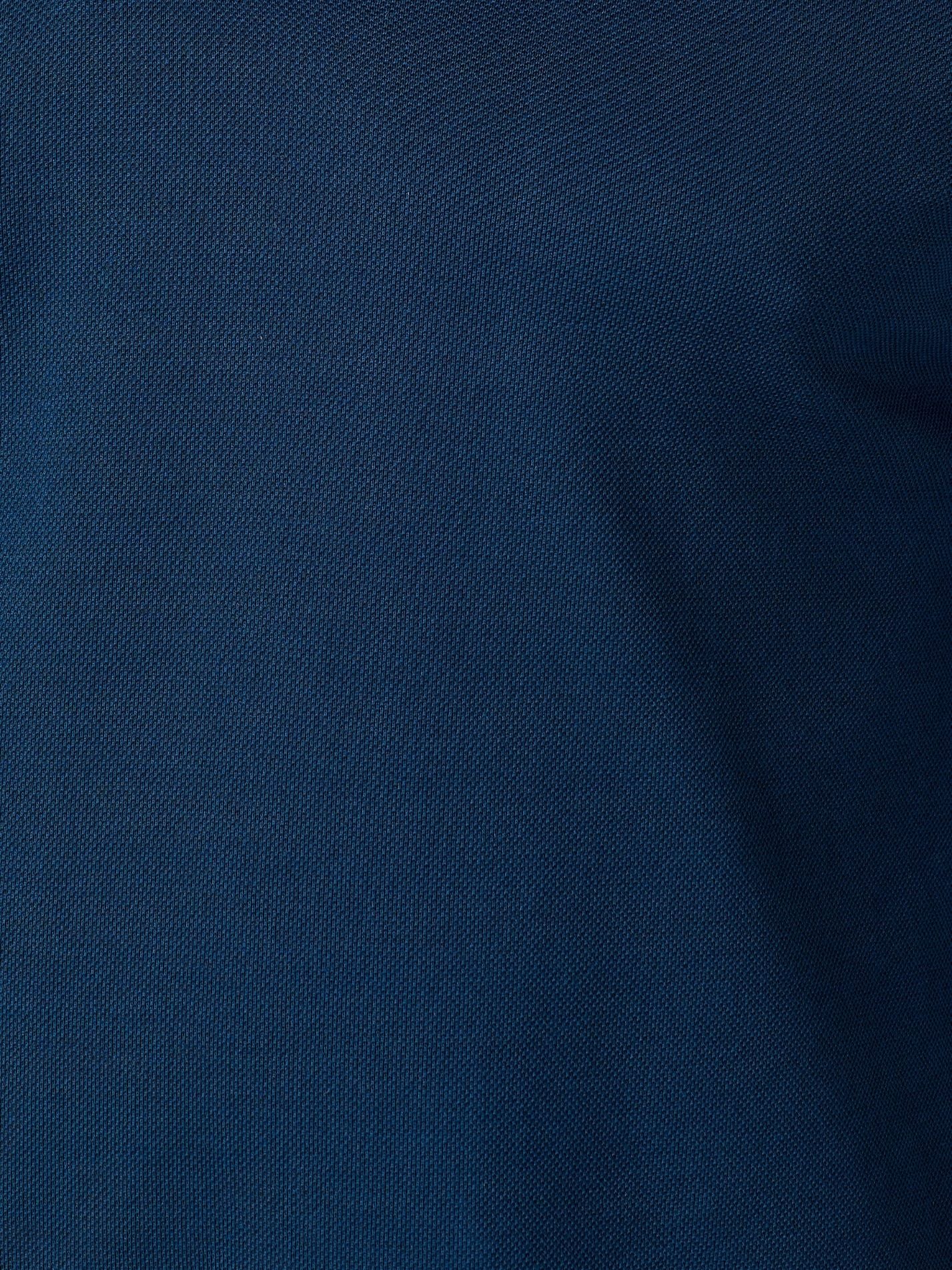 A close-up of dark navy blue fabric with a fine woven texture and soft folds.