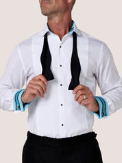 Koy white dress shirt worn with a black bow tie being tied, cuffs turned back to reveal blue Kikoy-striped lining